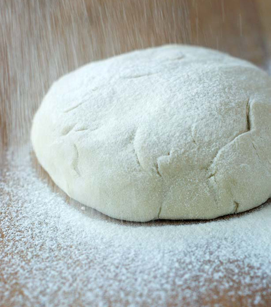 Oprószona mąką kula ciasta na pierogi i uszka.