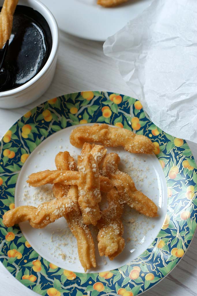 chrupiące, złote hiszpańskie churros, ciastka smażone z cukrem pudrem i sosem czekoladowym