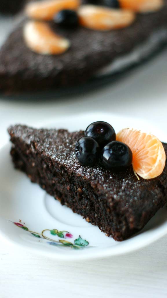 porcja ciasta czekoladowego ozdobiona mandarynką i borówkami