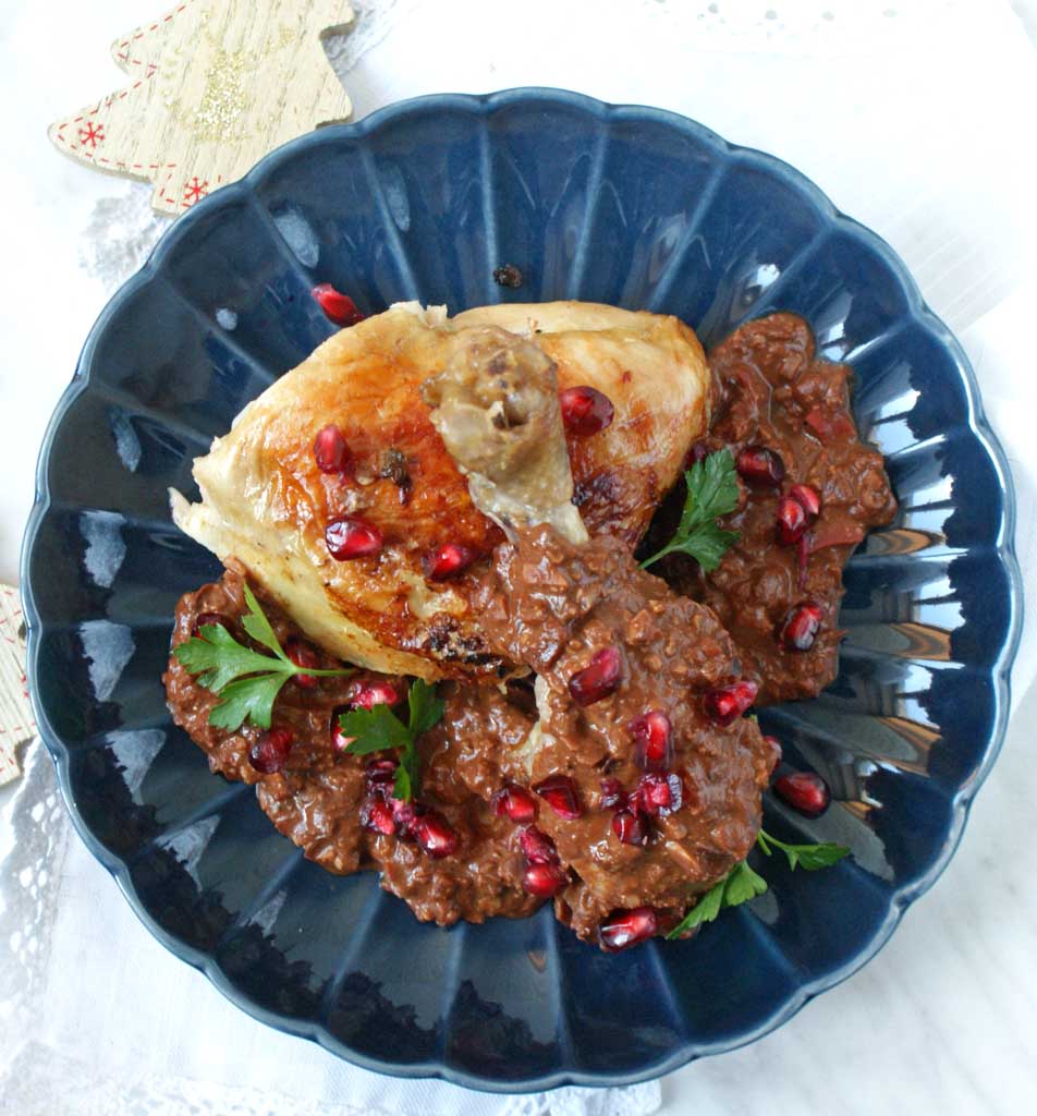 Pieczony, złocisty kurczak w kawałkach z sosem czekoladowym i granatem