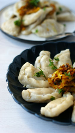 Obiadowa porcja wegetariańskich pierogów z soczewicą i cebulką.