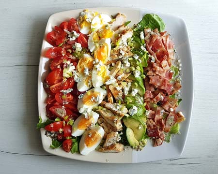 Składniki sałatki Cobb kurczak, boczk, jajka i warzywa.