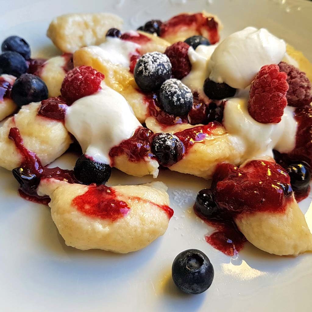 słodkie pierogi leniwe z owocami leśnymi i śmietaną