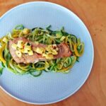 pieczony filet z łososia podany na warzywnym spaghetti z cukinii