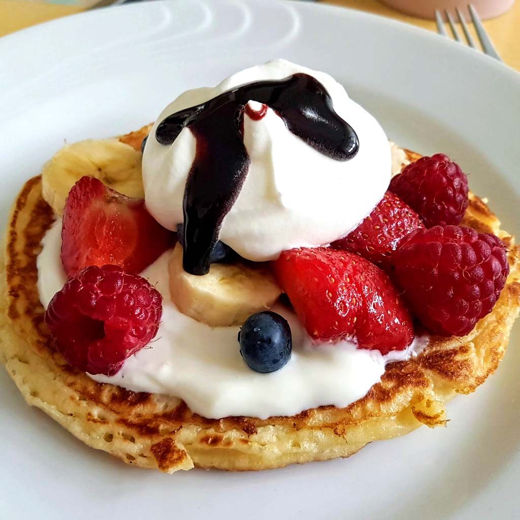 chrupiące placuszki pancakes z bitą śmietaną, owocami i czekoladą