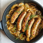 Biała kiełbasa pieczona w piwie podana z chrupiącą cebulą