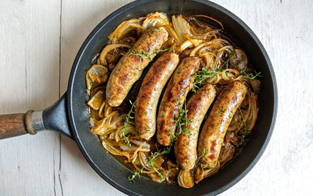 Biała kiełbasa pieczona w piwie podana z chrupiącą cebulą