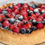 Smakowita tarta z aksamitnym kremem budyniowym i owocami jagodowymi.