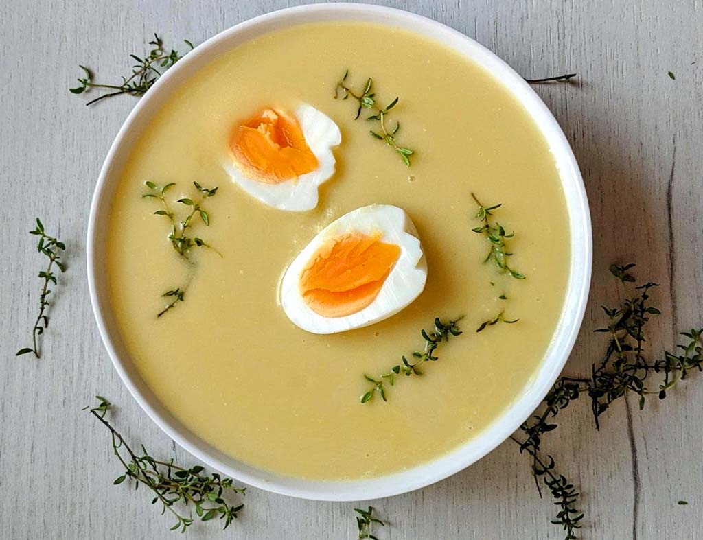 porcja wielkanocnej, kremowej zupy chrzanowej podaje z jajkiem na twardo